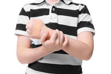 Photo of Little boy with sticking plaster on hand against light blue background, closeup
