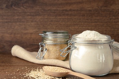 Photo of Jar with quinoa flour and seeds on wooden table