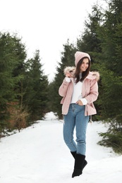 Photo of Young woman in snowy conifer forest. Winter vacation