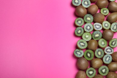 Photo of Many cut and whole fresh ripe kiwis on pink background, flat lay. Space for text