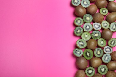 Many cut and whole fresh ripe kiwis on pink background, flat lay. Space for text