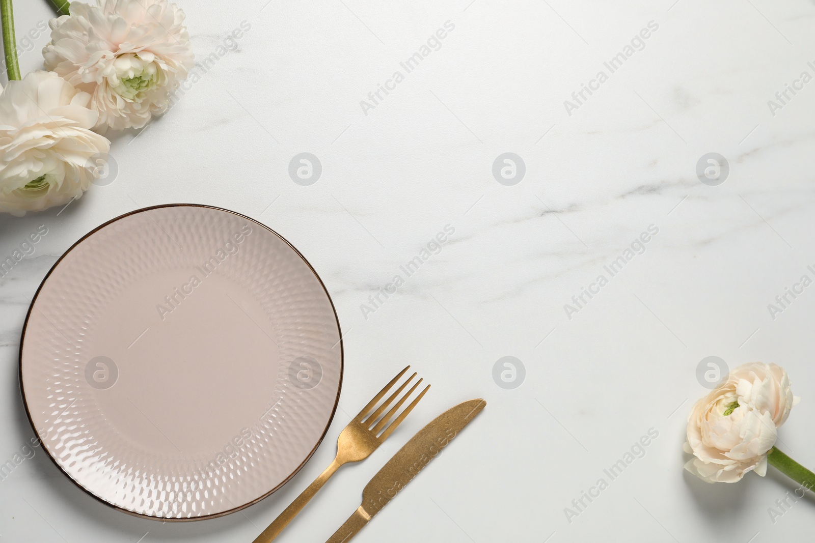 Photo of Stylish table setting with cutlery and flowers on white marble background, flat lay. Space for text