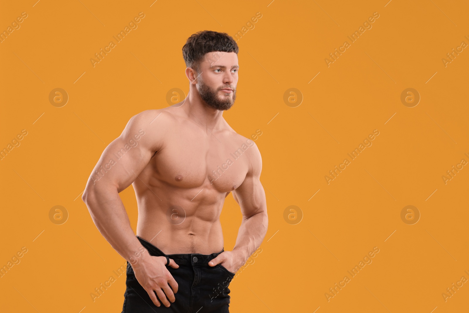 Photo of Handsome muscular man on orange background, space for text. Sexy body