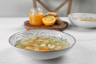 Bowl of fresh homemade soup to cure flu on wooden table