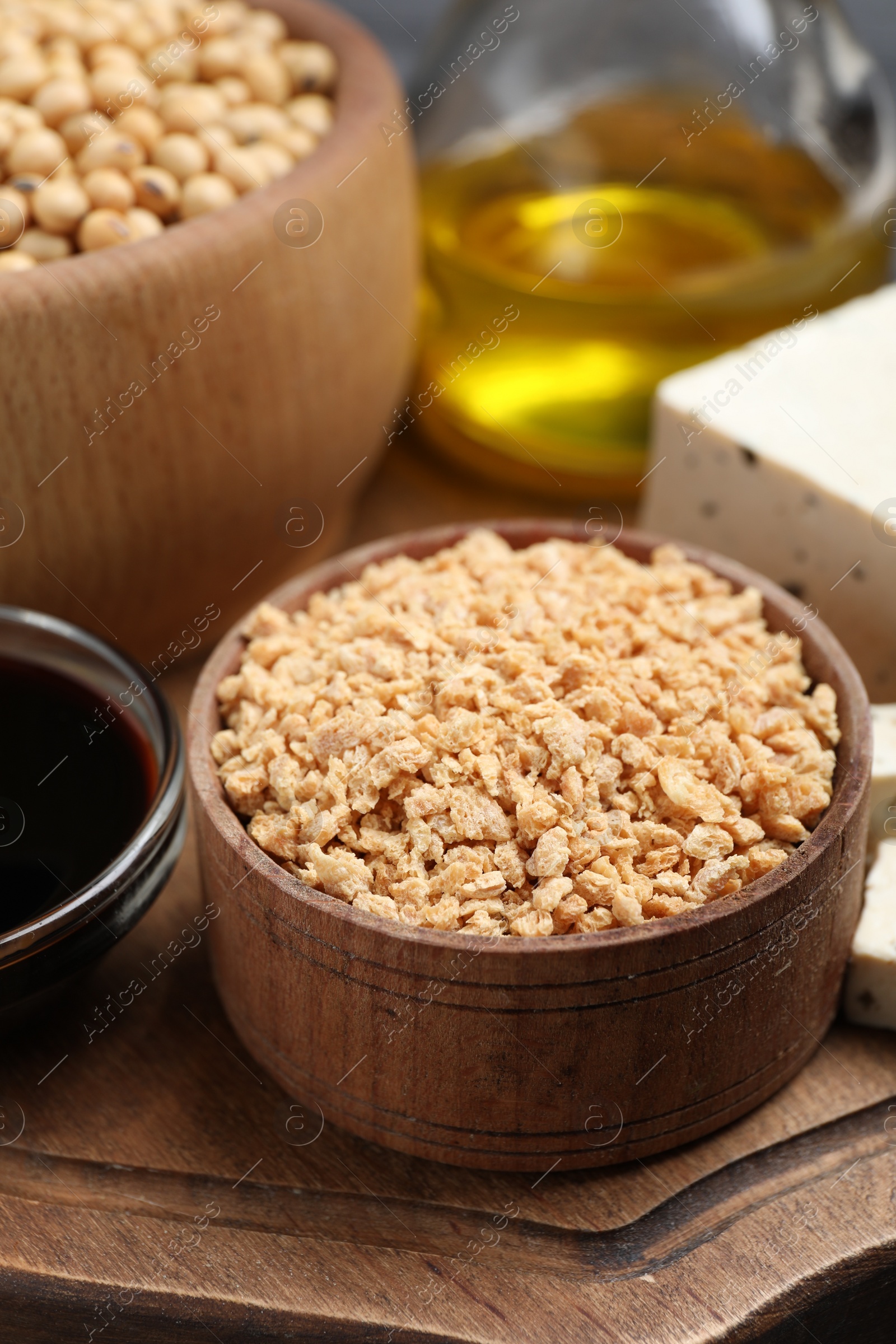 Photo of Dehydrated soy meat and other organic products on wooden board, closeup