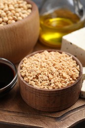 Dehydrated soy meat and other organic products on wooden board, closeup