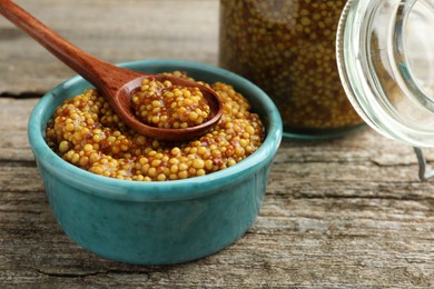 Photo of Whole grain mustard in bowl and spoon on wooden table