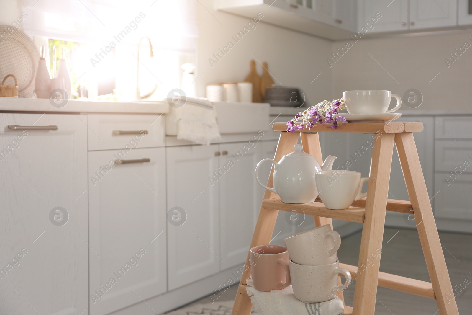 Photo of Decorative ladder with different dishware in kitchen. Idea for interior design