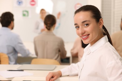 Photo of Happy woman at desk in class during lesson in driving school. Space for text