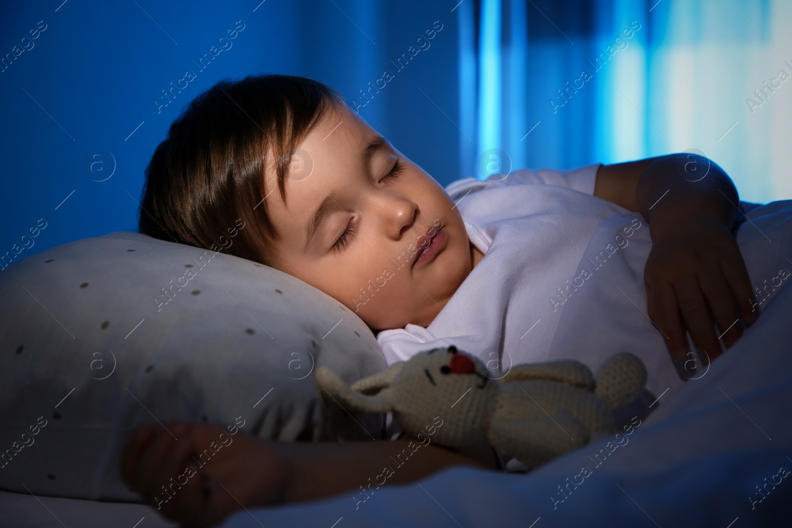 Photo of Cute little baby sleeping with toy at home. Bedtime