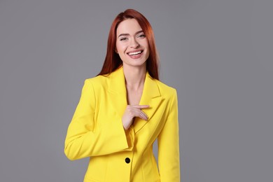 Photo of Beautiful woman with red dyed hair on light gray background