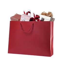 Photo of Dark red paper shopping bag full of gift boxes on white background