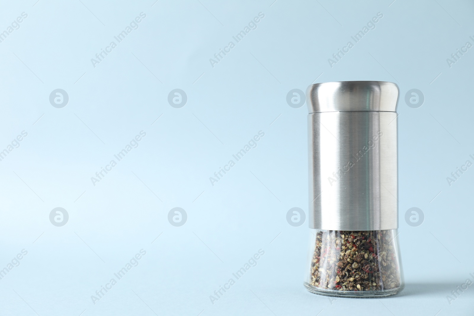 Photo of Pepper shaker on light background. Space for text