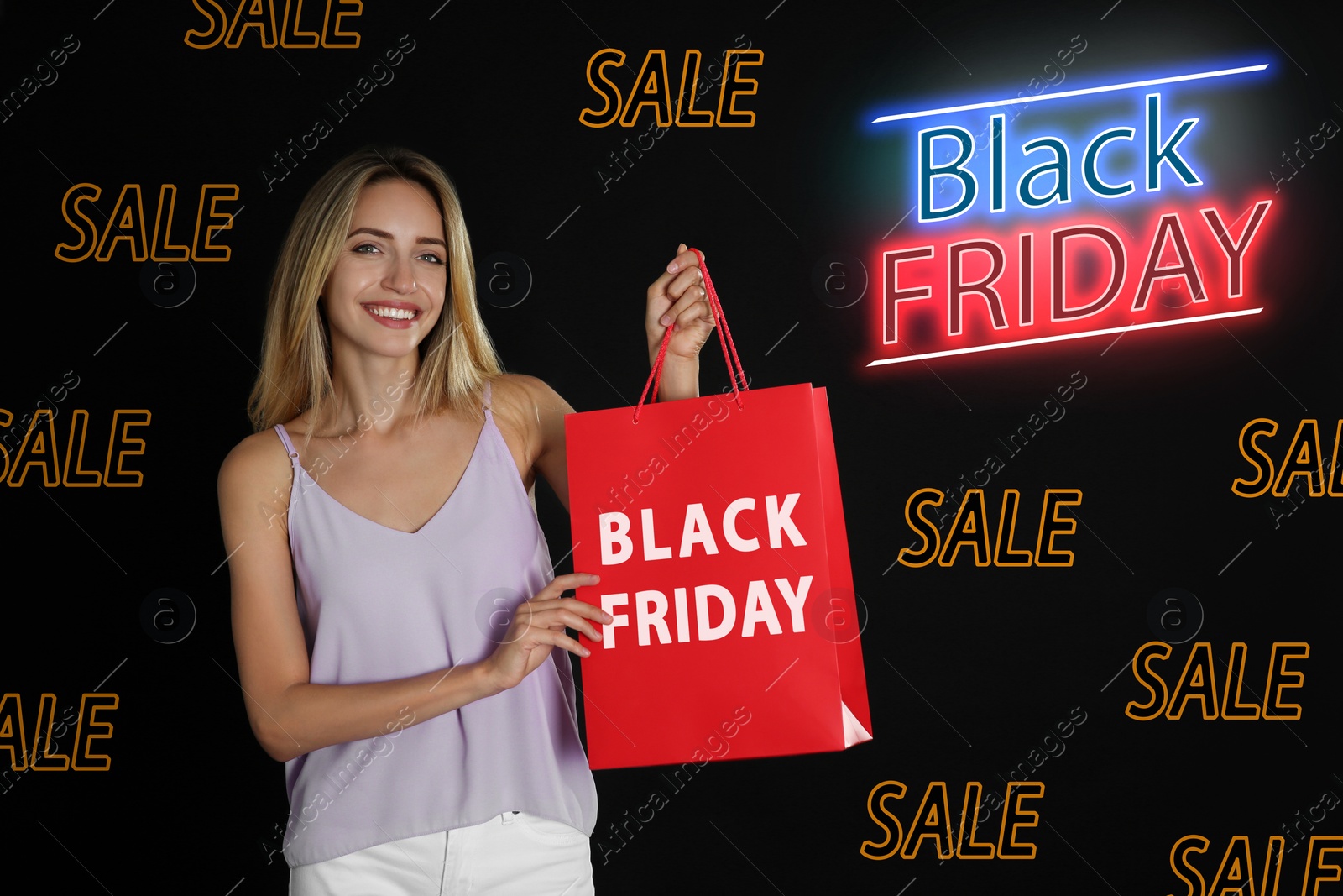 Image of Black Friday sale. Happy young woman with shopping bag on dark background