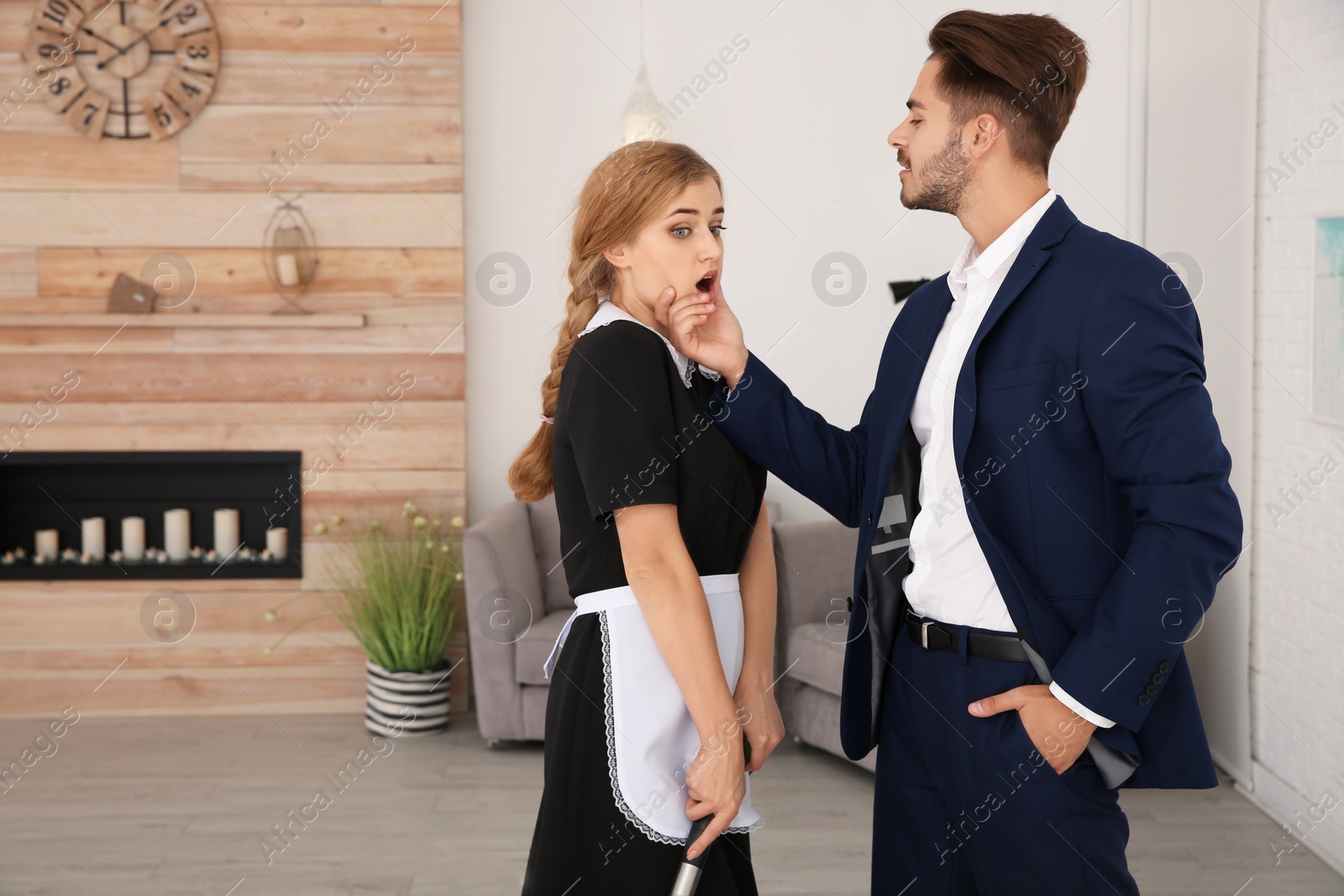 Photo of Young man sexually harassing chambermaid in hotel room. Space for text