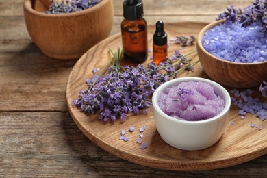 Photo of Plate with natural cosmetic products and lavender flowers on wooden table