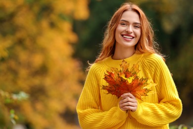 Portrait of happy woman with autumn leaves outdoors. Space for text