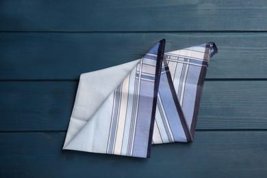 Stylish handkerchief on blue wooden table, top view