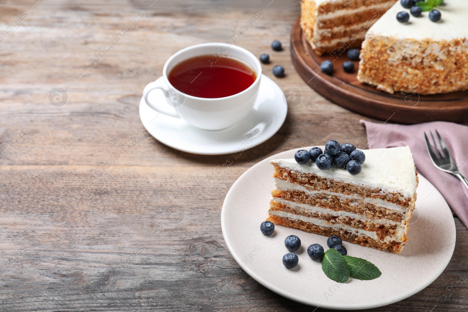 Photo of Tasty cake with berries on wooden table