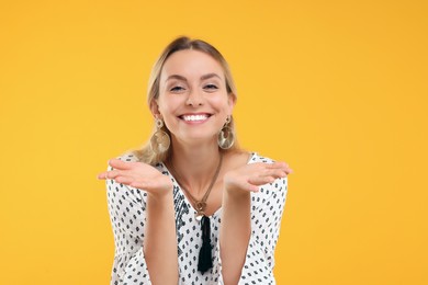 Photo of Portrait of smiling hippie woman on yellow background