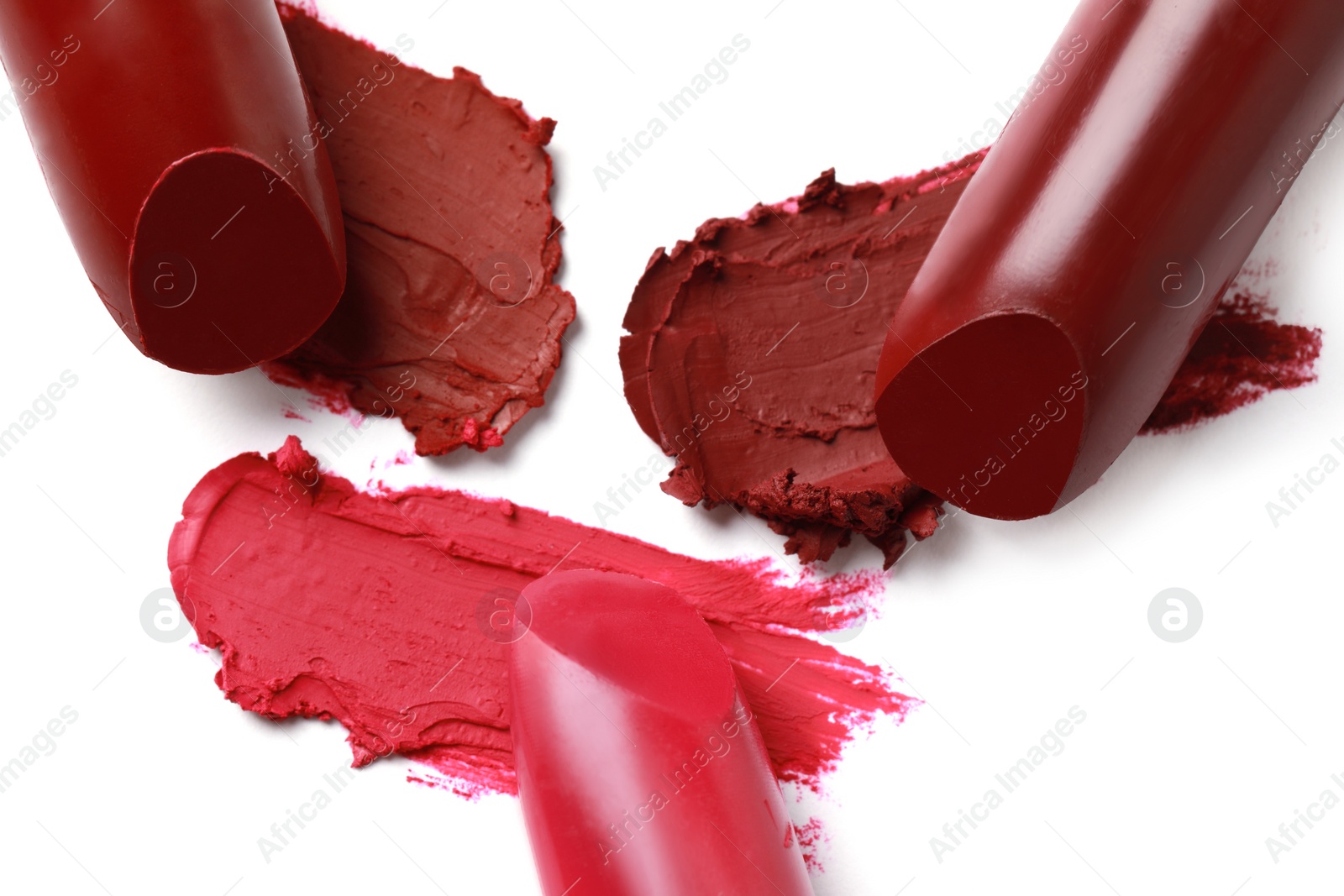 Photo of Different lipsticks and smears on white background, top view