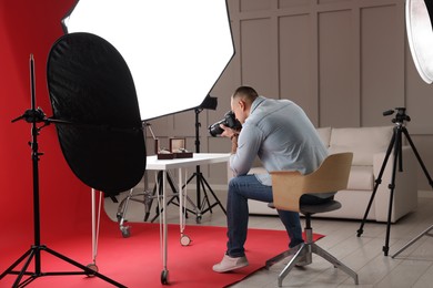 Photo of Professional photographer taking picture of expensive wristwatches in studio
