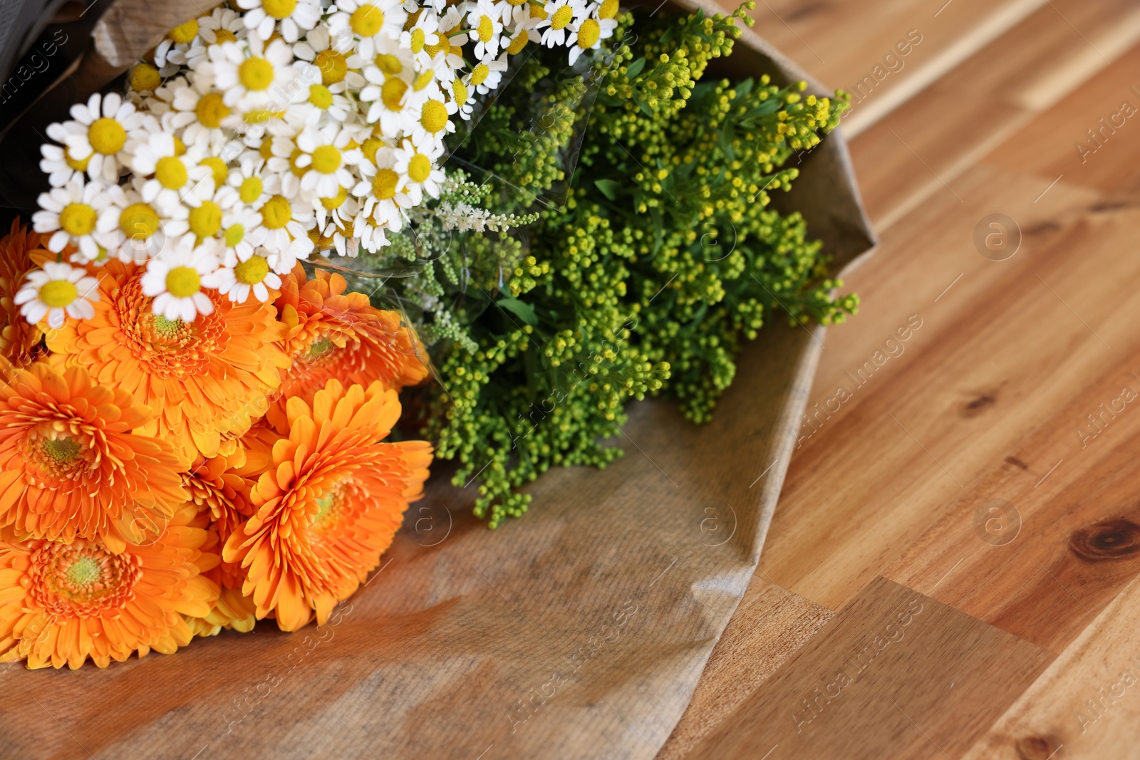 Photo of Beautiful bouquet with chamomile and daisy flowers on wooden table. Space for text