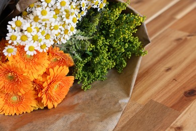 Photo of Beautiful bouquet with chamomile and daisy flowers on wooden table. Space for text