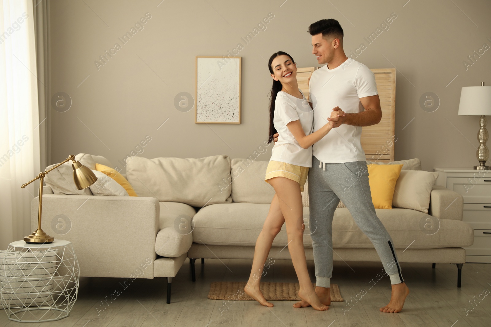 Photo of Happy couple in pyjamas dancing at home