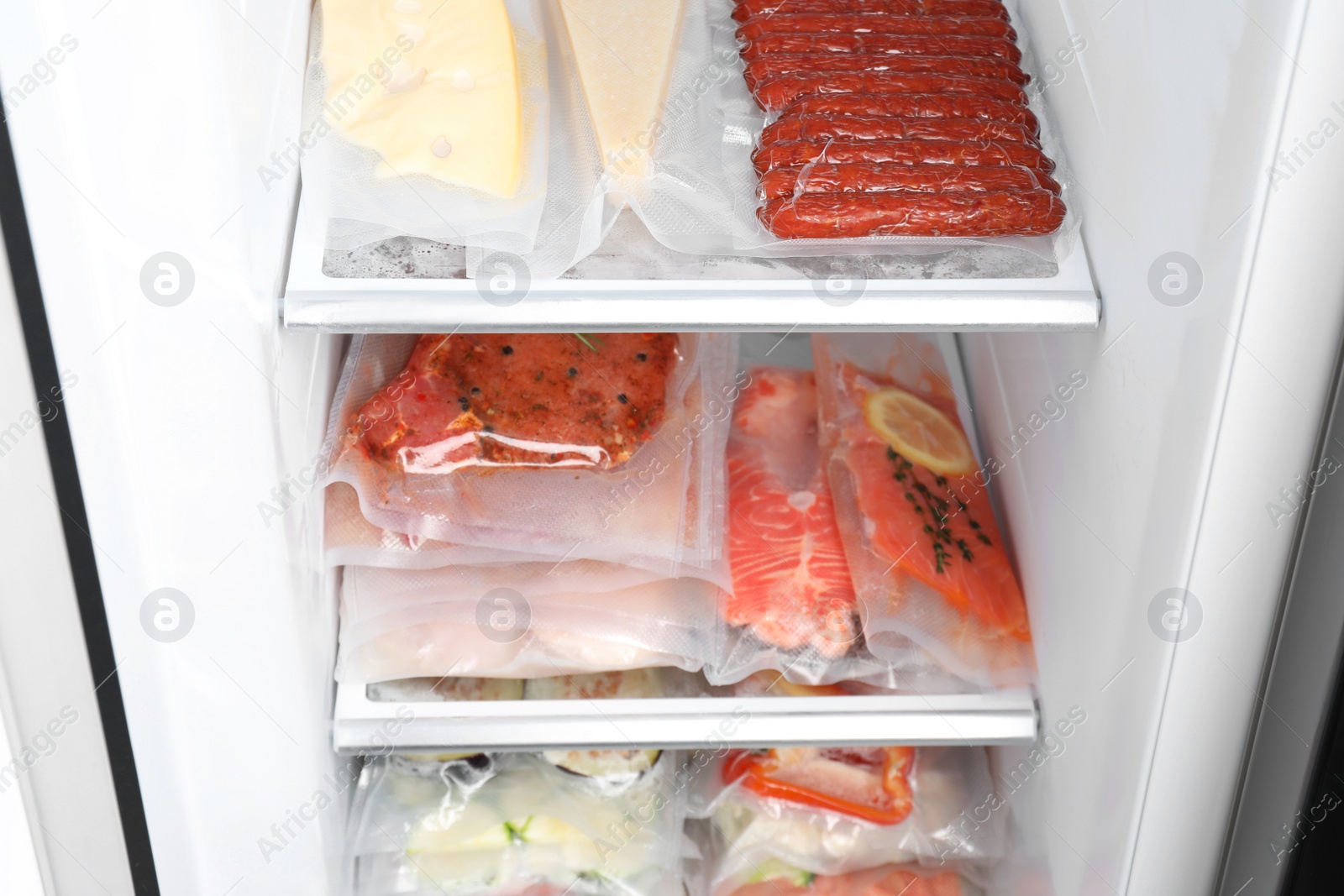 Photo of Vacuum bags with different products in fridge. Food storage