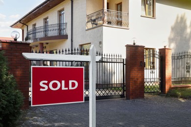 Red Sold sign near beautiful house outdoors