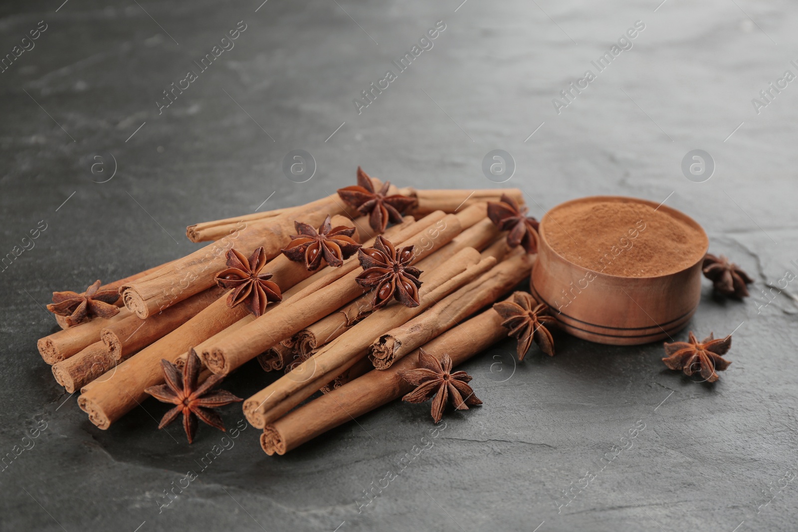 Photo of Aromatic cinnamon and anise on black table