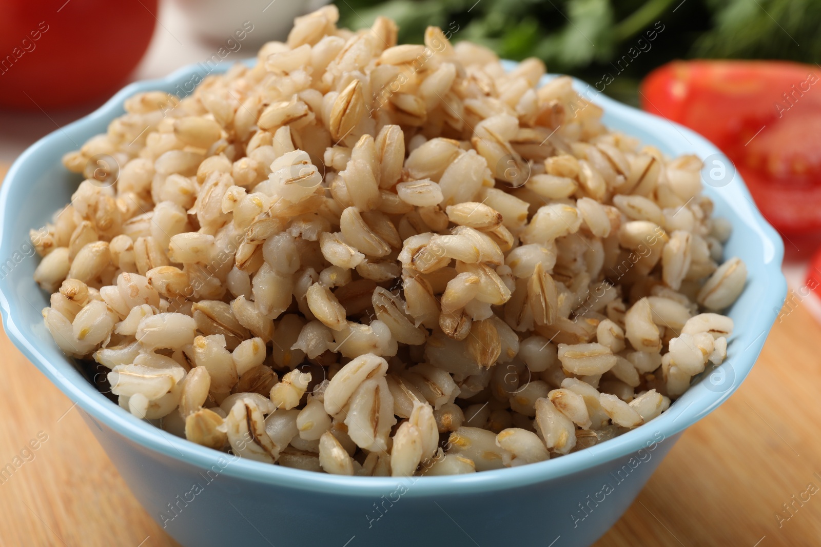 Photo of Delicious pearl barley in bowl on table, closeup