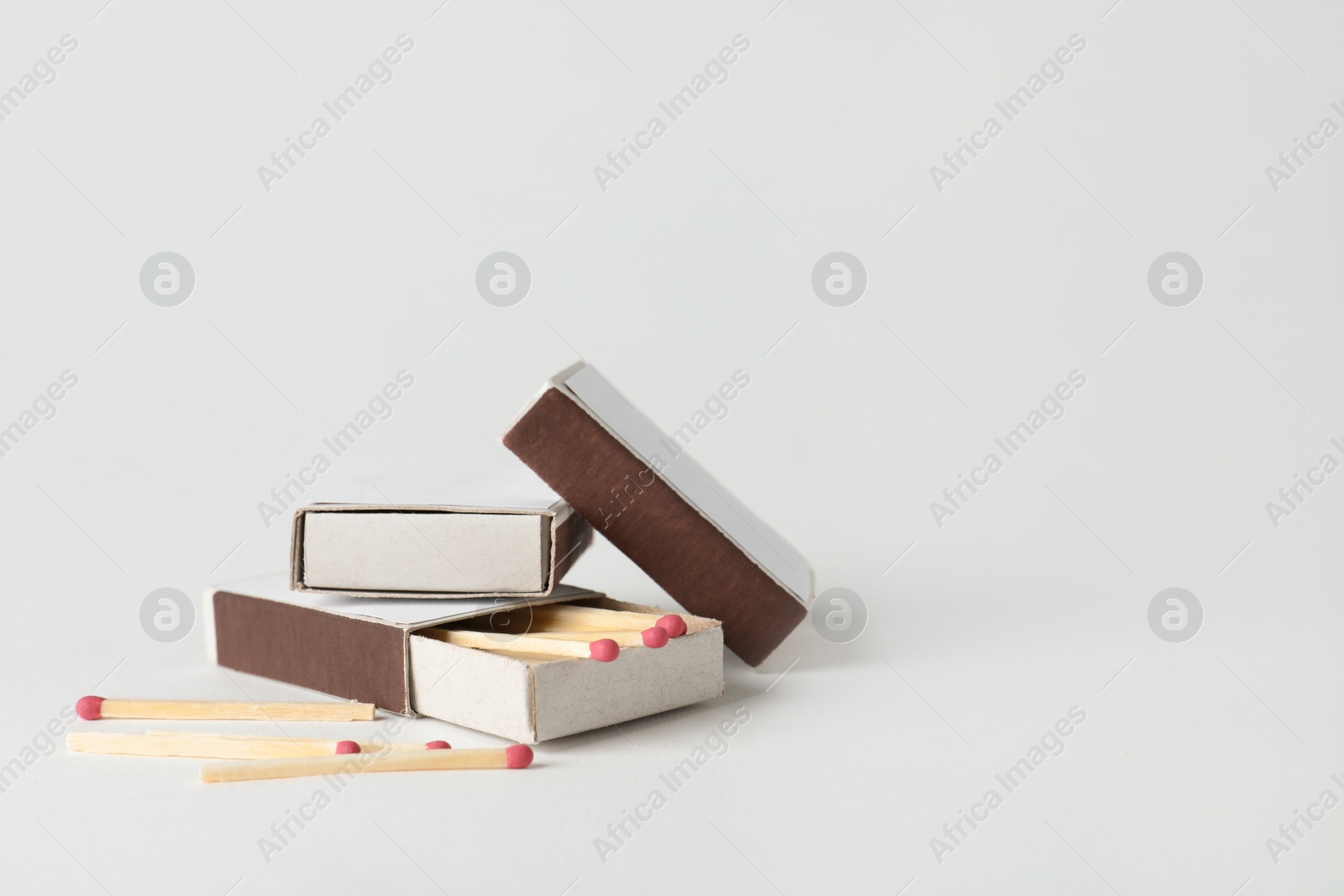 Photo of Cardboard boxes with matches on light background