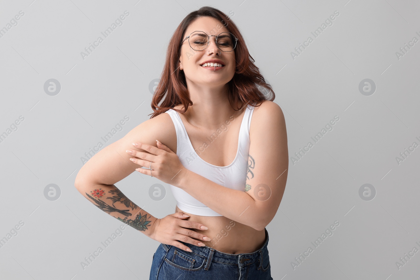 Photo of Portrait of beautiful tattooed woman on gray background