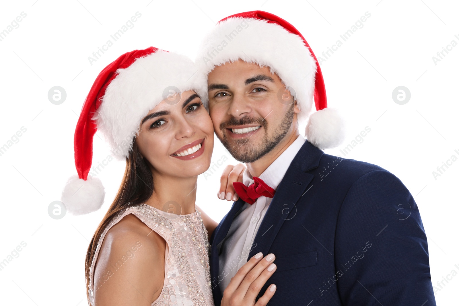 Photo of Lovely young couple in Santa hats on white background. Christmas celebration
