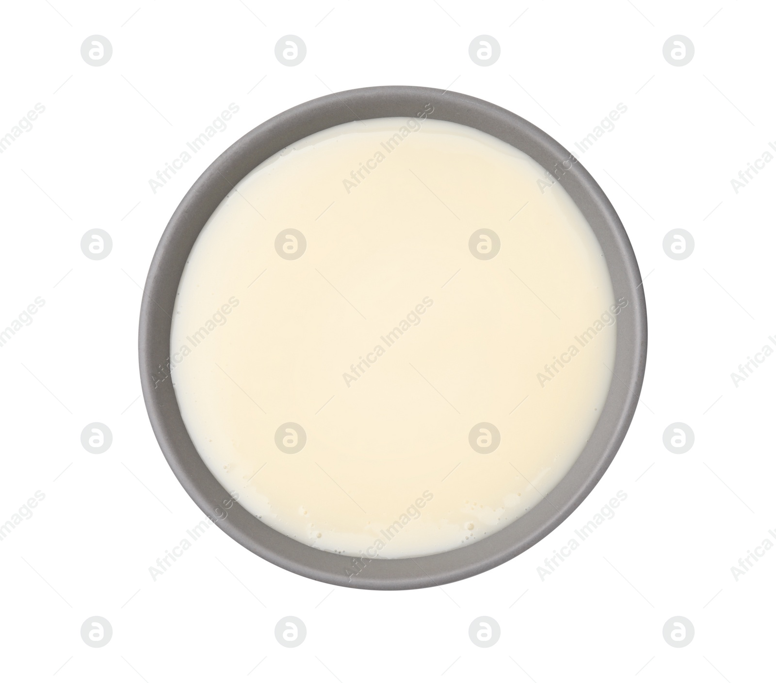 Photo of Bowl with condensed milk isolated on white, top view