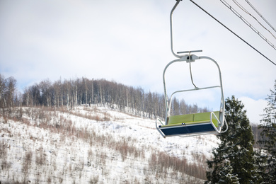 Photo of Empty chairlift at mountain ski resort. Winter vacation