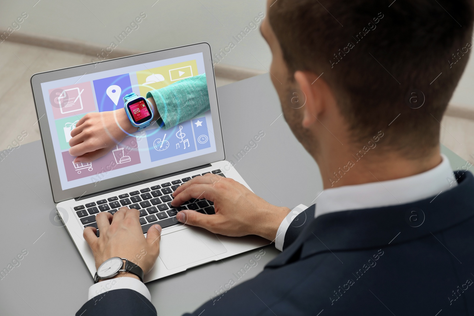 Image of Control kid's geolocation via smart watch. Man using laptop at table, closeup