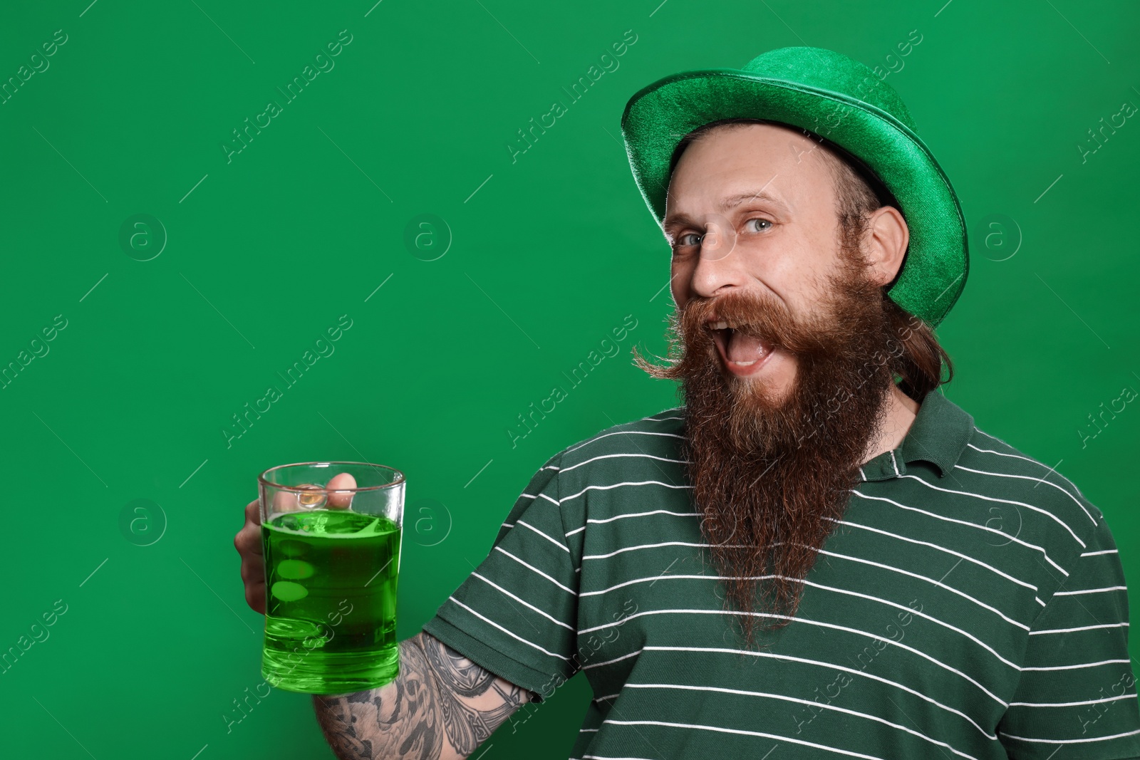 Photo of Bearded man with green beer on color background. St. Patrick's Day celebration