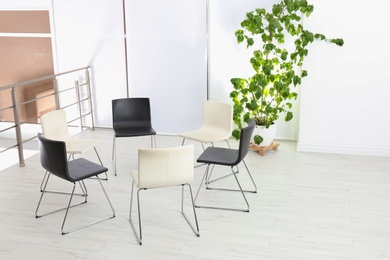 Photo of Empty chairs prepared for group psychotherapy session indoors