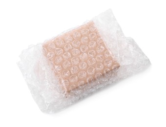 Photo of Cardboard box packed in bubble wrap isolated on white, above view