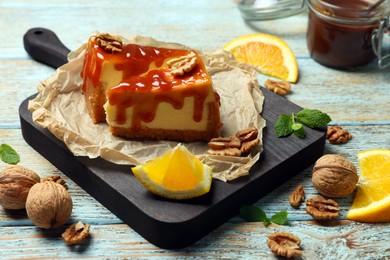 Photo of Pieces of delicious caramel cheesecake with walnuts and orange served on wooden table