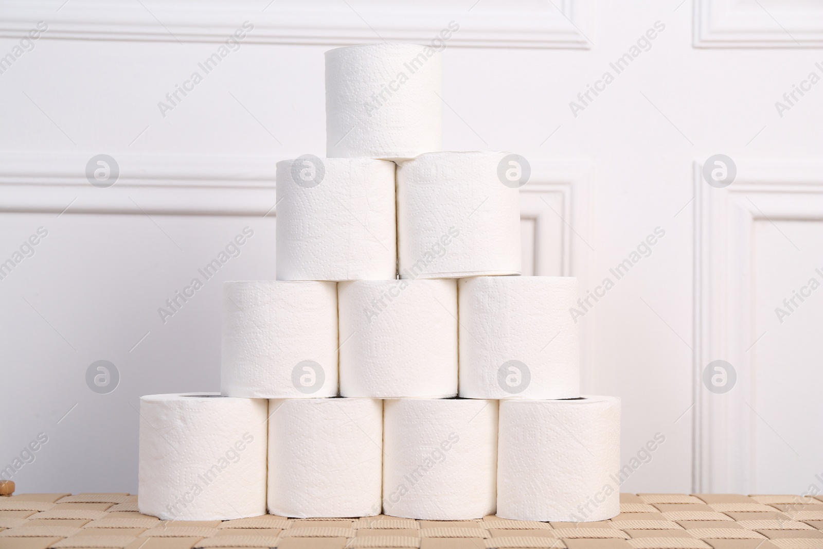 Photo of Pyramid of toilet paper rolls on wicker table