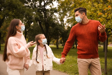 Photo of Lovely family walking together in park during coronavirus pandemic