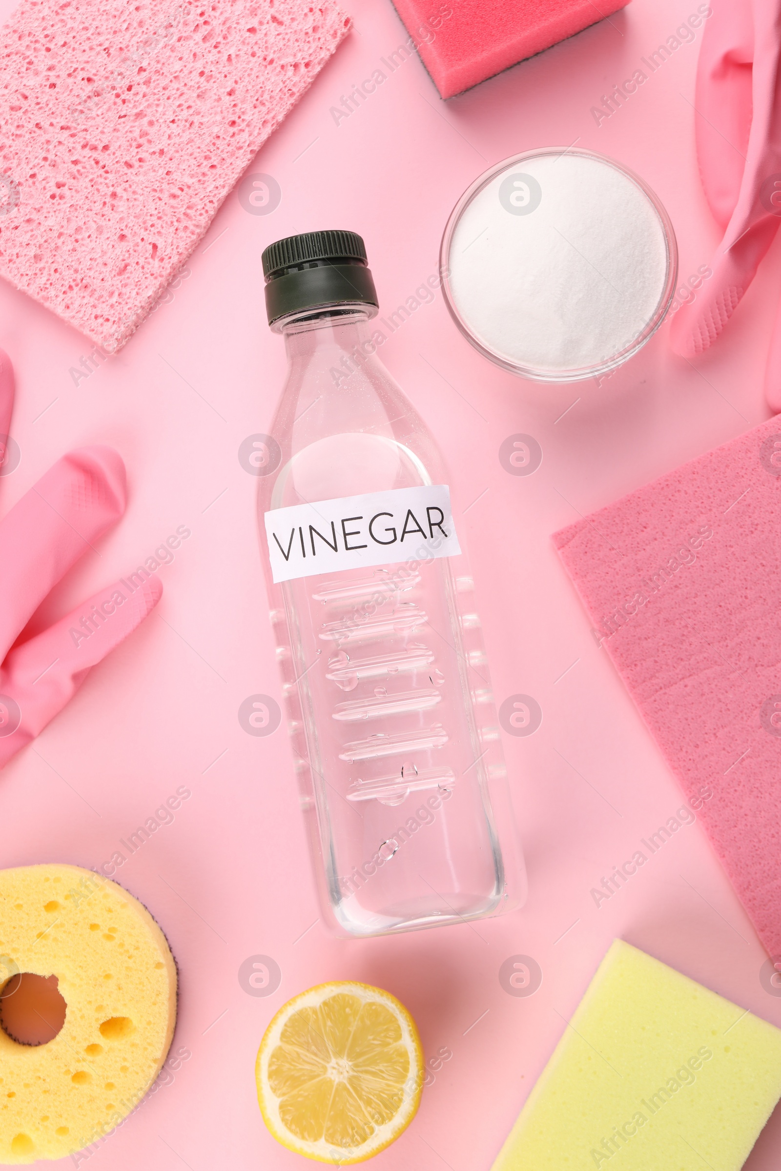 Photo of Eco friendly natural cleaners. Flat lay composition with bottle of vinegar on pink background