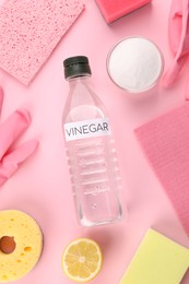 Photo of Eco friendly natural cleaners. Flat lay composition with bottle of vinegar on pink background