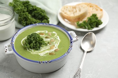 Photo of Tasty kale soup with pumpkin seeds on light grey marble table