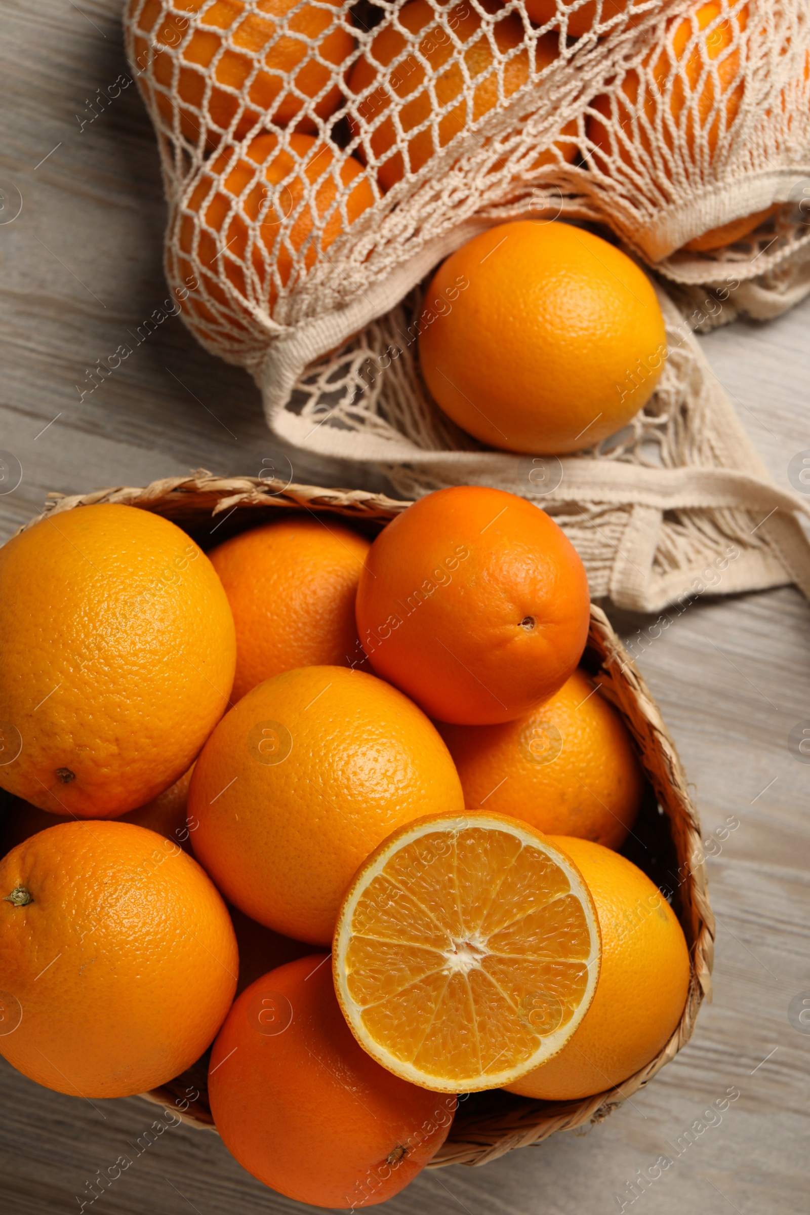 Photo of Many whole and cut oranges on wooden table, flat lay