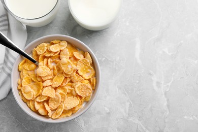 Photo of Tasty cornflakes with milk served on grey marble table, flat lay. Space for text